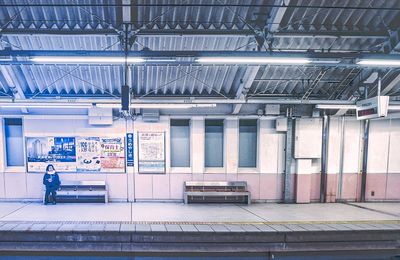 Rear view of man standing on railroad station platform