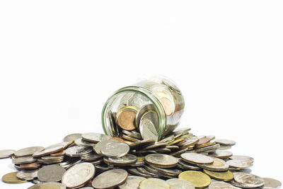 Close-up of coins on glass against white background