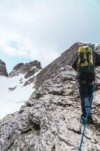 Rear view of snow on rock against sky