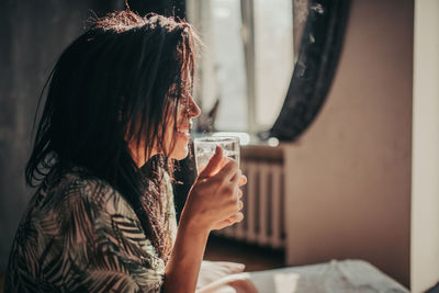 Side view of woman drinking glass