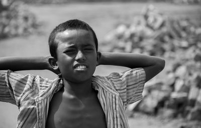 Portrait of boy with hands behind head