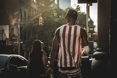 Rear view of man standing on street in city