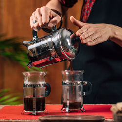 Midsection of woman making coffee in cafe