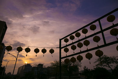 Low angle view of street lights against sky at sunset