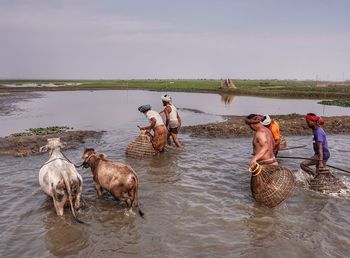 Group of people in water against sky