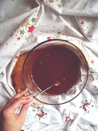 High angle view of woman holding tea cup on table