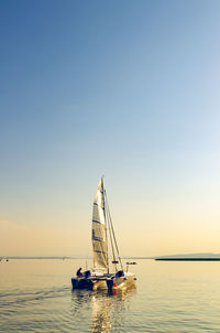 Sailboat in sea against clear sky