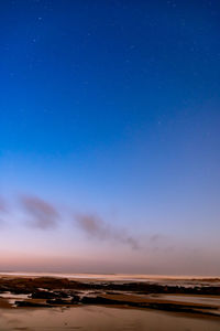 Scenic view of land against clear blue sky at night