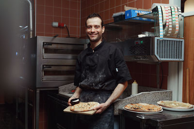 Chef preparing pizza in restaurant kitchen