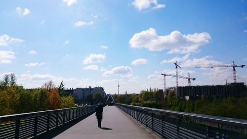 Man on bridge against sky