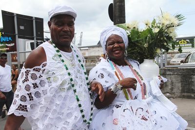 Man holding woman with umbrella while standing outdoors