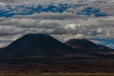 Scenic view of mountain range against cloudy sky