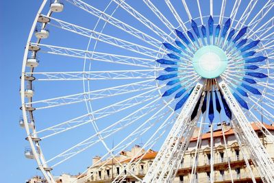 Low angle view of ferris wheel against blue sky