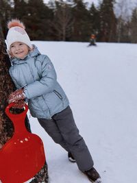 Portrait of young man skiing on snow covered field