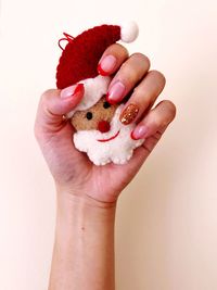 Close-up of hand holding ice cream over white background