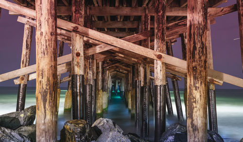 Low angle view of pier over sea against sky