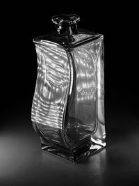 Close-up of glass jar on table against black background