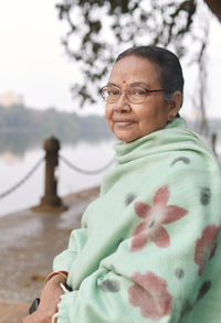 An elegant looking aged bengali woman enjoying nature at rabindra sarobar lake in a winter evening.