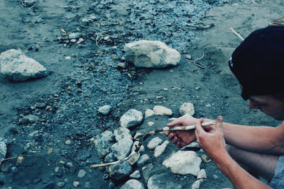 High angle view of man holding stick on land