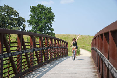 Man riding bicycle on footbridge