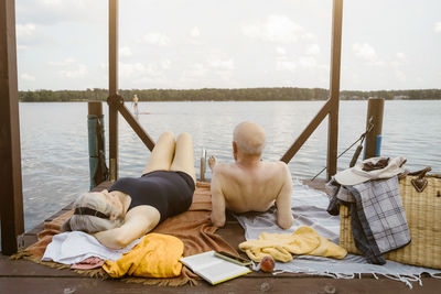 Senior couple lying together on gazebo over river