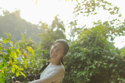 Portrait of woman standing against plants