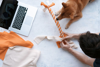 Adult man making diy homemade educational toys for dogs using a tutorial from the internet