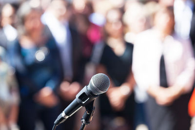 Close-up of microphone against audience