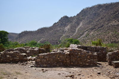 Stone wall against mountain range against clear sky