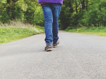 Low section of man walking on road