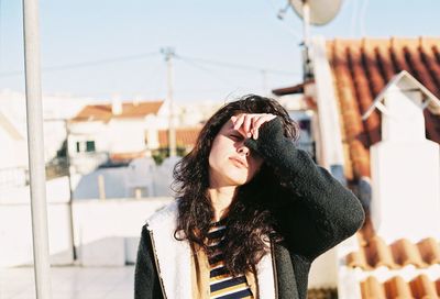 Woman standing on building terrace during sunny day