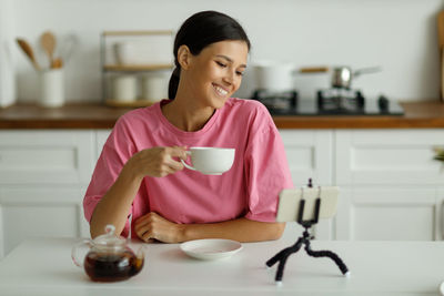 Portrait of young woman sitting at home