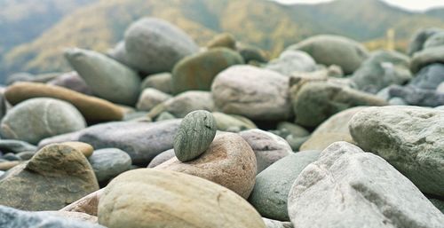 Nature theories, uttarakhand, india- bokeh of weathered pebble stacked by shore