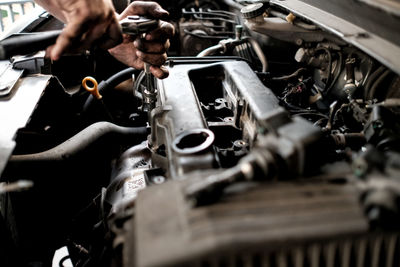 Cropped hand of mechanic repairing car at garage