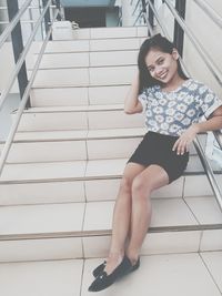 Portrait of smiling young woman on steps