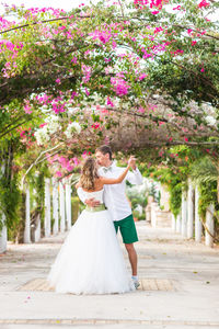 Woman holding flower bouquet against plants