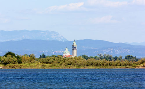 Lighthouse by sea against sky