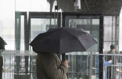 Man holding umbrella in rain during monsoon