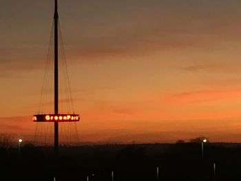 Silhouette of sailboat against orange sky
