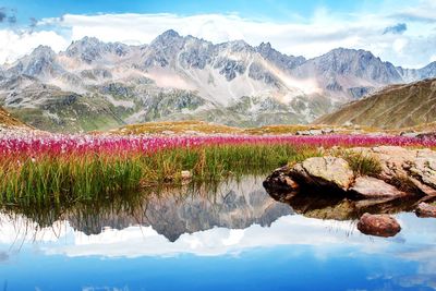 Scenic view of lake by mountains against sky