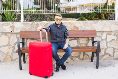 Full length of man sitting on bench