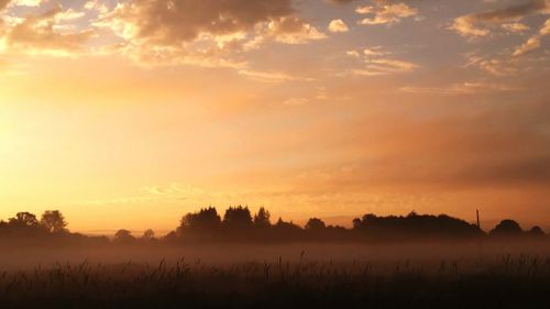 Scenic view of landscape at sunset in the fog