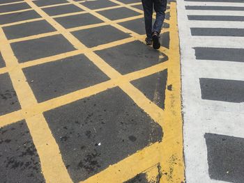 Low section of person walking on zebra crossing