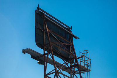 Low angle view of old tower against clear blue sky