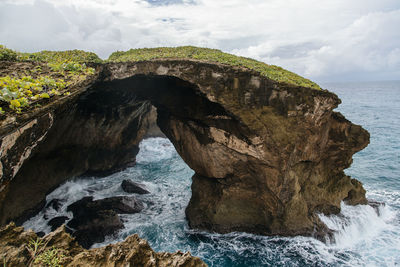 Rock formations by sea against sky