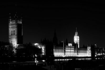 Illuminated buildings against clear sky at night