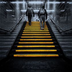 Rear view of people walking on staircase