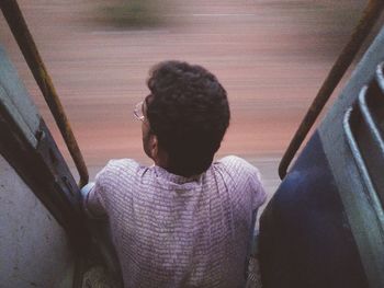 Rear view of man looking through window