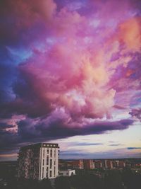 Buildings against dramatic sky during sunset