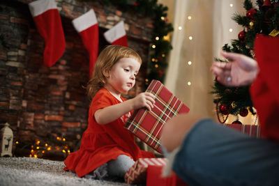 Portrait of smiling young woman holding christmas tree